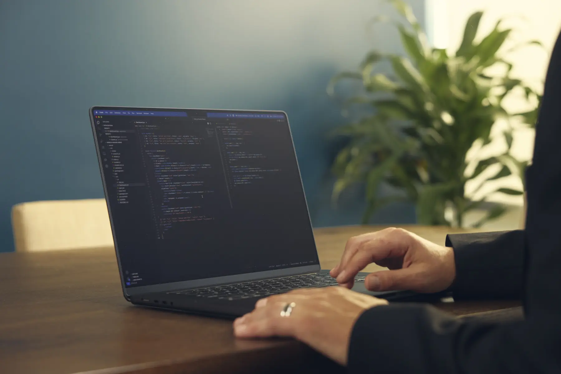 Hands on a laptop keyboard with code on screen at the INSPIRED Vibe office