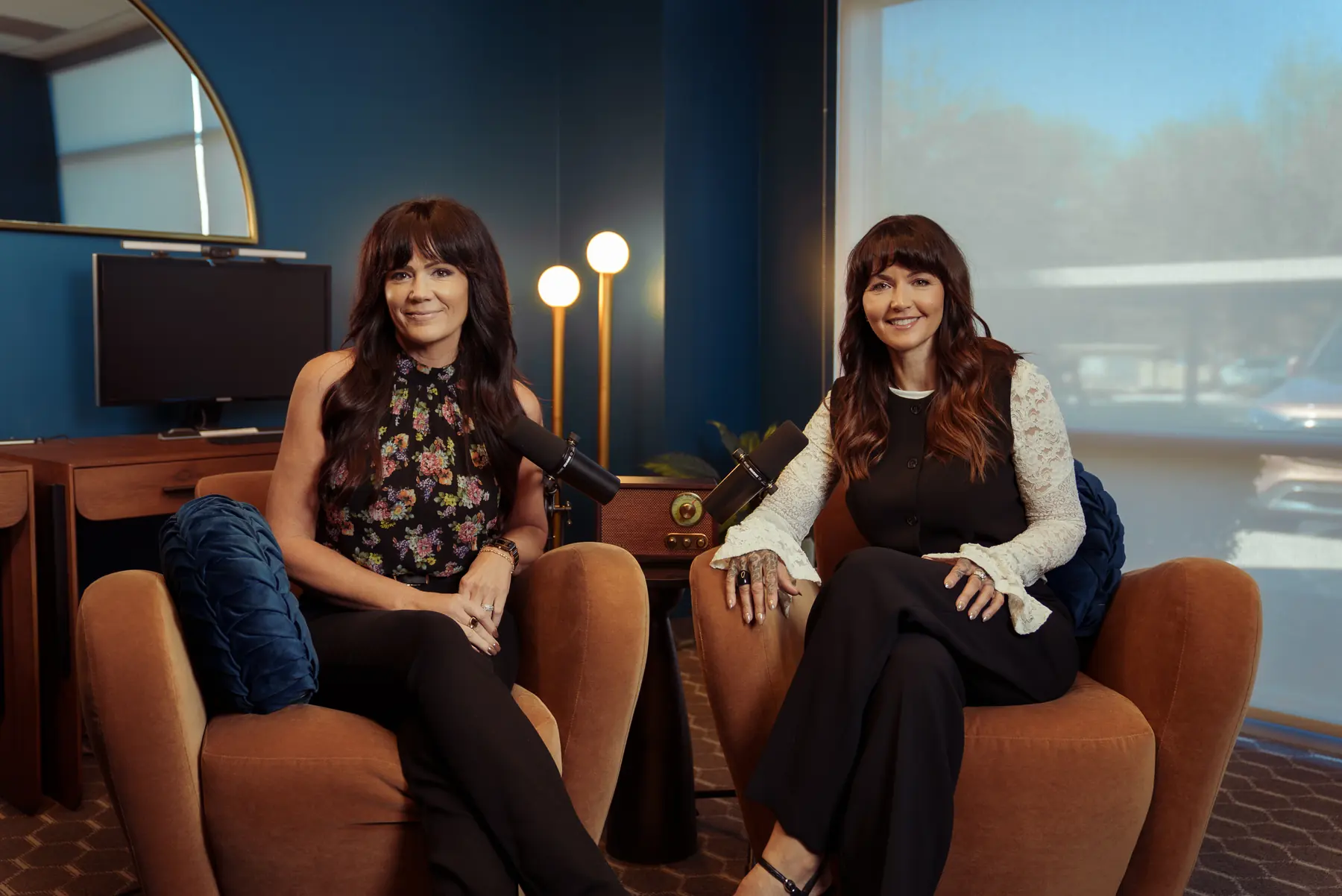 Christin Daniels and Amber Halvorson seated with microphones at the start of an episode